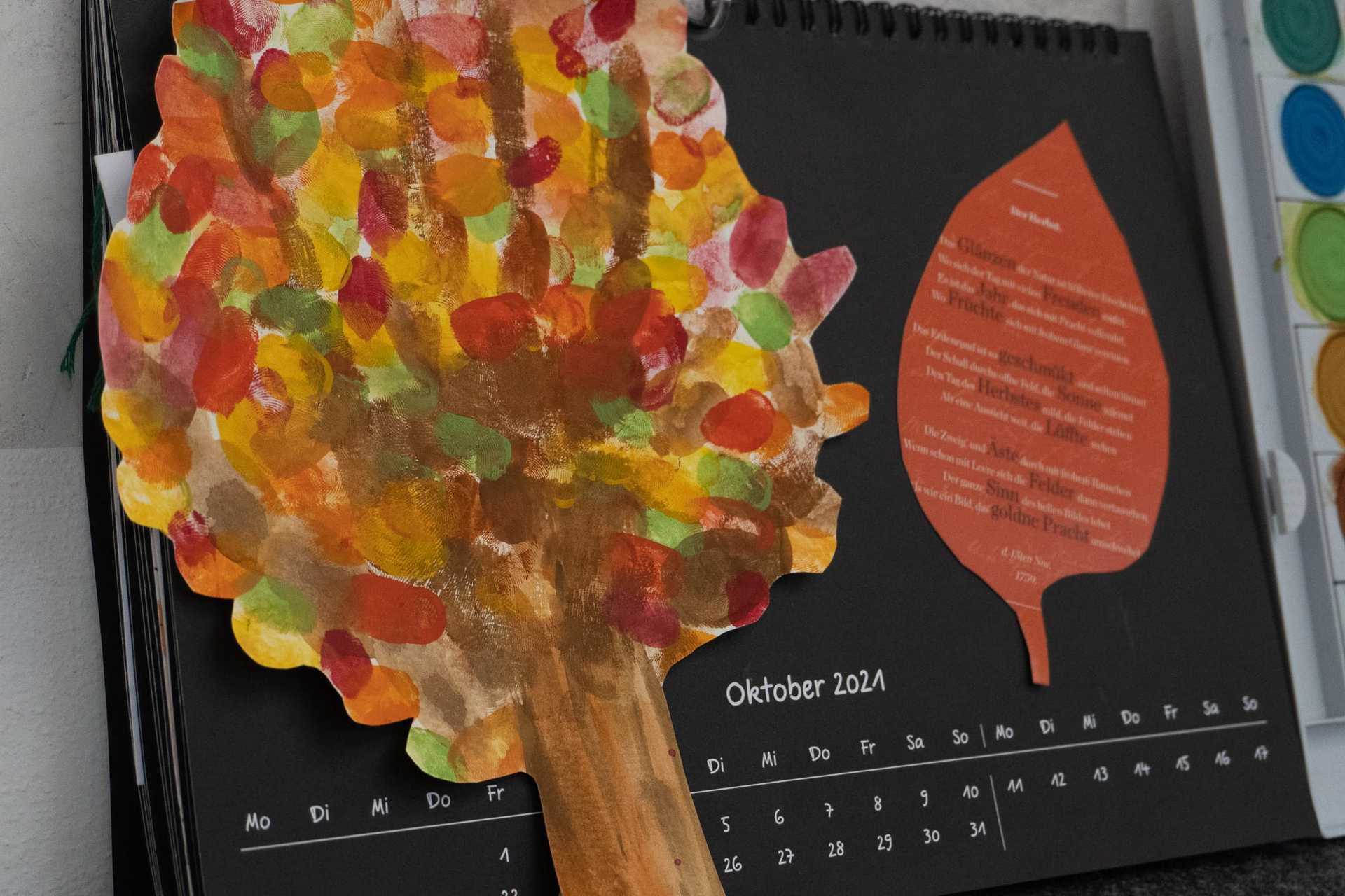 Detailansicht der fertigen Kalenderseite. Bunte Buchstaben und ein handgeschriebenes Gedicht