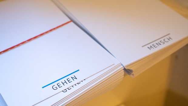 Bedruckte Postkarten mit den Wörtern gehen und Mensch.