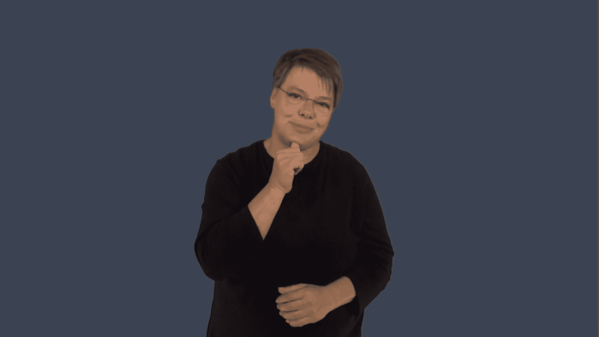 Die Gebärdensprach-Linguistin Dr. Daniela Happ trägt ein schwarzes Hemd und steht vor einem dunkelblauen Hintergrund.