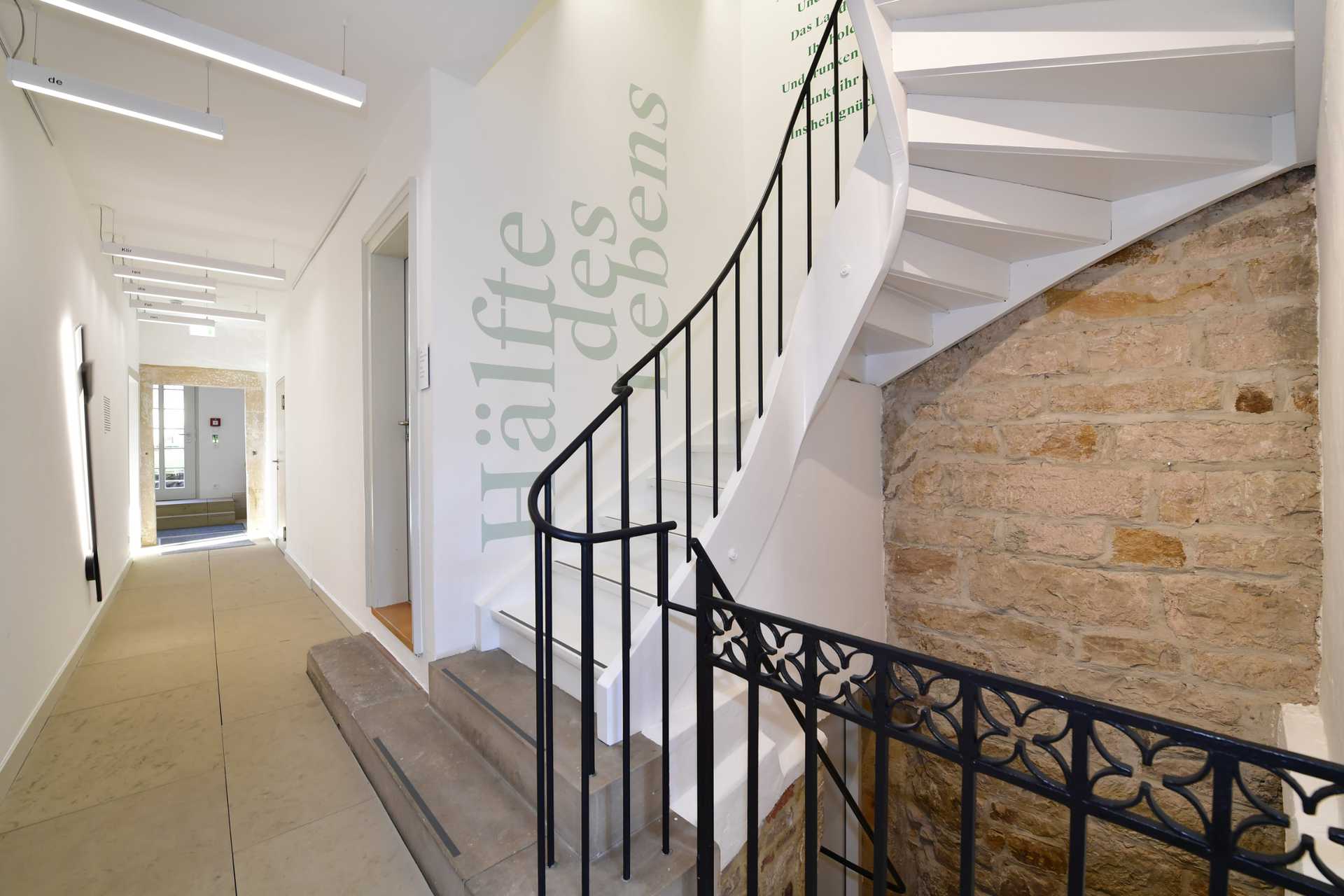 Der Flur im Erdgeschoss des Turms: An der Wand schwingt ein Metronom. Die Lichtschienen und der Text im Treppenhaus beziehen sich auf Hölderlins Gedicht ›Hälfte des Lebens‹