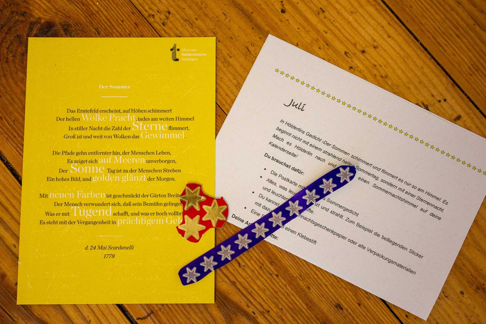 Die Anleitung zum Kalenderblatt, das Sommer-Gedicht und Klebestreifen mit Glitzersternen