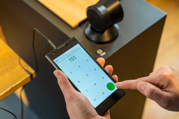 Une personne tape un nombre dans le dispositif de guide média.