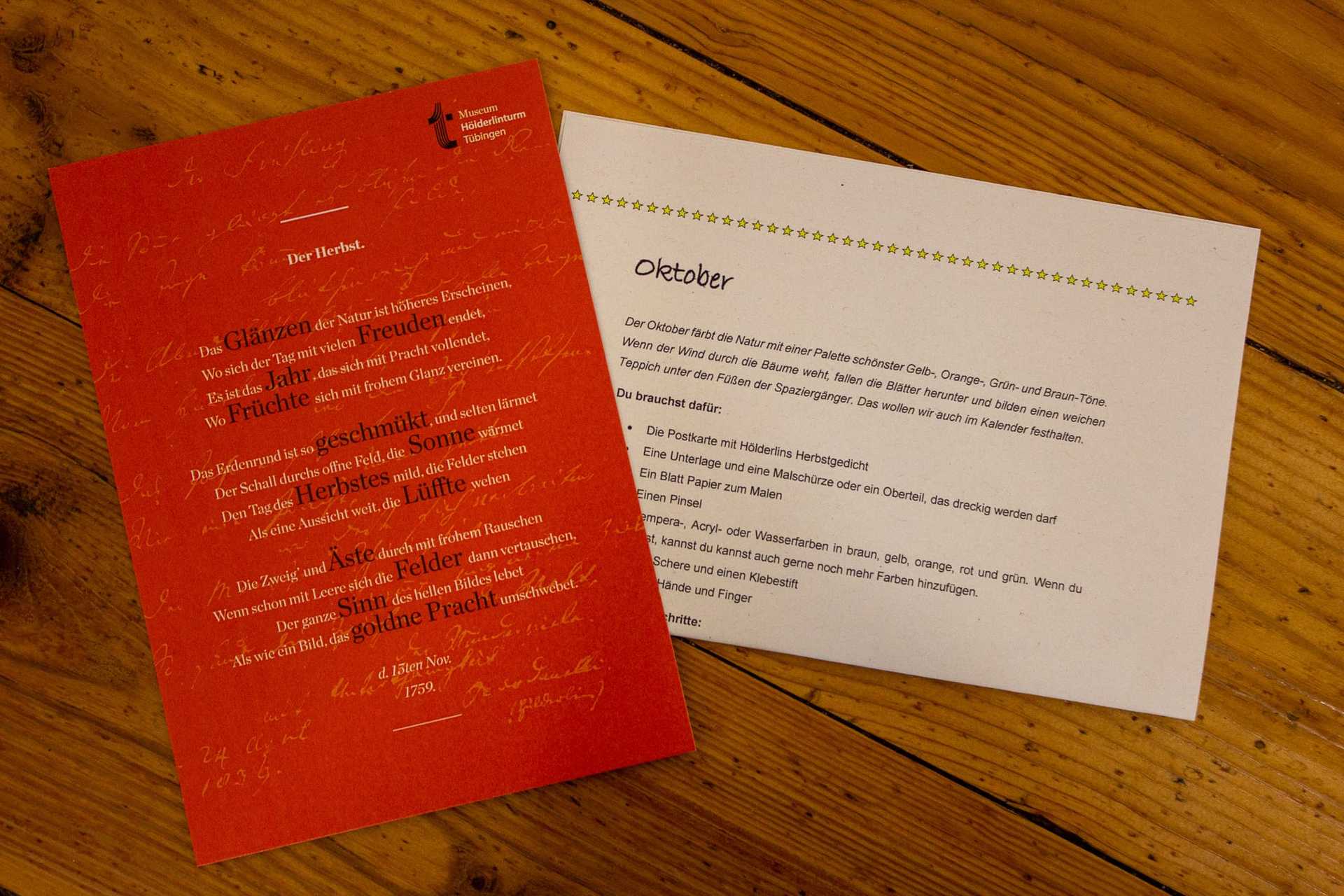 Die Anleitung zum Kalenderblatt und eine orangene Postkarte mit Hölderlins Herbstgedicht