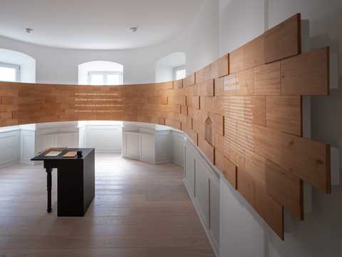 Bild des ersten Raumes der Dauerausstellung: Das Gedicht ›Die Linien des Lebens…‹ auf Holzschindeln