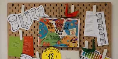 Eine Pinnwand mit einem Kalender und vielen Bastelmaterialien.