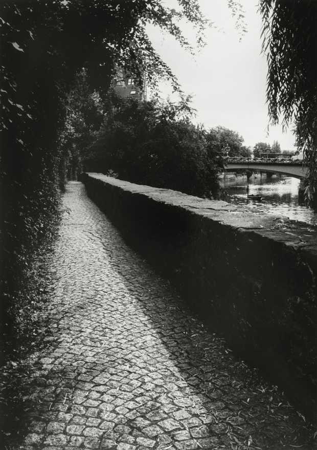 Ein schwarz-weiß Foto zeigt einen schmalen Weg vor dem Höderlinturm.